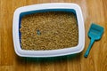 Cat`s litter box with filler and scoop on floor Royalty Free Stock Photo