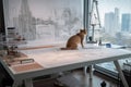 cat sits on drafting table, sketching out the design for a futuristic skyscraper