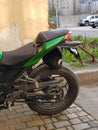 Cat sitting on beautiful green Kawasaki motorcycle