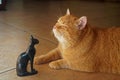 Ancient gods, cat in sunlight with statue of goddess Bastet Royalty Free Stock Photo