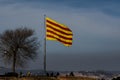 Catalan flag fluttering in the wind with a cloud of pollution and Barcelona in the background
