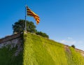 Catalan flag flying over the walls of the MontjuÃÂ¯c Castle in Barcelona, Spain Royalty Free Stock Photo