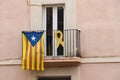 Catalan independence flag and yellow ribbon hanging from a window demanding the independence of Catalonia and the freedom of the