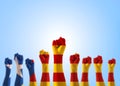 Catalan separatism concept with Senyera estelada Eastern Catalan lone star flag on people`s hand fists isolated on blue sky