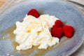 Catalan whey cheese, mato, served on plate with raspberries and honey