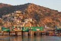 Catalina Island vacation resort, Avalon, California, green pleasure pier reflected in calm ocean, colorful houses perched on hills Royalty Free Stock Photo