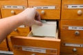 Catalog with information in an open wooden box. Man`s hand holds a paper card. Search data in storage. Database concept Royalty Free Stock Photo