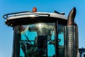 Catalyst tractor and cab with large windows close up on a background of blue sky. Exhaust pipe of a modern bulldozer