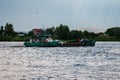 catamaran ferry boat sailing across the danube river near the delta in romania with a house in the background Royalty Free Stock Photo