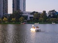 Catamaran in the form of a swan on a pond. boat with people on the lake. Leisure. City park with a lake Royalty Free Stock Photo