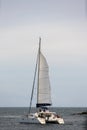 Catamaran sailboat with group of people heading out to the sea Royalty Free Stock Photo