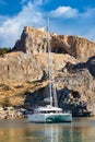 Catamaran in St. PaulÃÂ´s bay, cloudy blue sky, Lindos acropolis Royalty Free Stock Photo