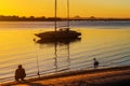 Catamarand sailboat moored in bay of Bribie Island on Sunshine Coast of Queensland Australia at sunset with bridge and volcanic Royalty Free Stock Photo