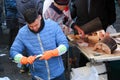 Catania, Italy - Apr 10th 2019: Young fisherman scaling and gutting fish on famous Sicilian fish market. Pulling out of roe