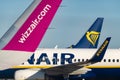 Airplanes of low-cost airlanes like Wizzair with focus on the Ryanair plane and its logo in the background