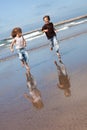 cheerful children running on the beach on sunny summer day Royalty Free Stock Photo