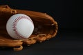 Catcher`s mitt and baseball ball on black background, space for text. Sports game Royalty Free Stock Photo