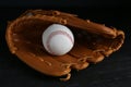 Catcher`s mitt and baseball ball on black background. Sports game Royalty Free Stock Photo
