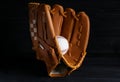 Catcher`s mitt and baseball ball on black background. Sports game Royalty Free Stock Photo