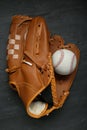 Catcher`s mitt and baseball ball on black slate background, top view. Sports game Royalty Free Stock Photo