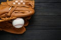 Catcher`s mitt and baseball ball on black wooden table, top view with space for text. Sports game Royalty Free Stock Photo