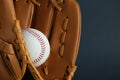 Catcher`s mitt and baseball ball on dark background, closeup with space for text. Sports game Royalty Free Stock Photo