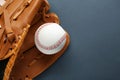 Catcher`s mitt and baseball ball on dark background, top view with space for text. Sports game Royalty Free Stock Photo