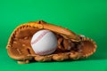 Catcher\'s mitt and baseball ball on green background. Sports game