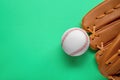 Catcher`s mitt and baseball ball on green background, top view with space for text. Sports game Royalty Free Stock Photo