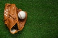 Catcher\'s mitt and baseball ball on green grass, top view with space for text. Sports game Royalty Free Stock Photo