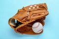 Catcher`s mitt and baseball ball on light blue background, top view. Sports game Royalty Free Stock Photo