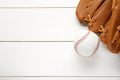 Catcher`s mitt and baseball ball on white wooden table, top view with space for text. Sports game Royalty Free Stock Photo