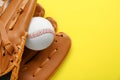 Catcher\'s mitt and baseball ball on yellow background, top view with space for text. Sports game Royalty Free Stock Photo