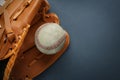 Catcher`s mitt and worn baseball ball on dark background, top view. Space for text Royalty Free Stock Photo