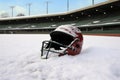 a catchers helmet on a snowy pitchers mound in an empty winter ballpark Royalty Free Stock Photo