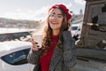 Catching girl with excited face expression drinking coffee on the street in windy cold day. Gorgeous caucasian lady with Royalty Free Stock Photo