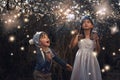 Catching some magical creatures. two little siblings catching fireflies in jars outside.