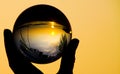 Catching Sunset In Crystal Ball On Tropical Island Ko Lanta. Close Up Of Hand Silhouette Holding Glass Sphere Ball With Reflection