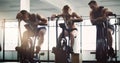 Catching their breath. Full length shot of three young people sitting on elliptical trainers while working out in the Royalty Free Stock Photo