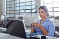 Catching up on emails during her coffee break. a young businesswoman drinking a beverage while using a laptop at work.