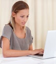 Catching up on a few emails. A young woman sitting inside and working on her laptop. Royalty Free Stock Photo