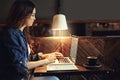 Catching up on her email correspondence. a relaxed young woman using her laptop in a coffee shop.