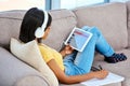 Catching up with the latest tunes. a teenage girl listening to music and using a tablet at home. Royalty Free Stock Photo