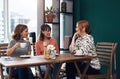 Catching up on the local gossip. a group of attractive middle aged women having a coffee date together as friends inside