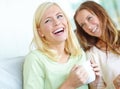 Catching up over coffee. Two attractive young women smiling while having coffee together. Royalty Free Stock Photo