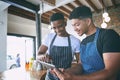 Catchy digital marketing keeps the doors open. two young men using a digital tablet while working in a cafe. Royalty Free Stock Photo