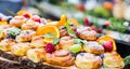 Catering buffet food outdoor. Cakes colorful fresh fruits berries oranges grapes and herb decorations Royalty Free Stock Photo