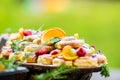 Catering buffet food outdoor. Cakes colorful fresh fruits berries oranges grapes and herb decorations Royalty Free Stock Photo