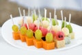 Catering for party. Close up of appetizers with watermelon, grapes, melon, kiwi, cheddar, parmesan, blue cheese over white plate Royalty Free Stock Photo
