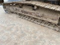 The caterpillar of a excavator or bulldozer stands on a construction site. The steel tracks are covered with dry earth. Close up Royalty Free Stock Photo